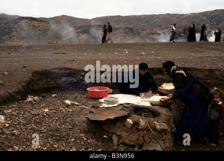 KURDISTAN', WOMEN MAKING BREAD IN TRADITIONAL KURDISH EARTHEN OVEN, PENJUIN, OCTOBER 1991 Stock Photo