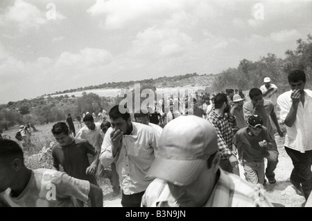 a group of palestinians run away from an israeli attack during a protest against the building of the israeli separation barrier. Stock Photo