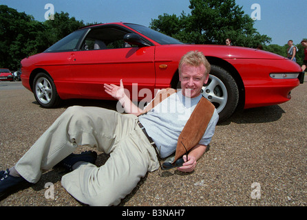 Les Dennis Comedian TV Presenter December 97 Layingon ground show of the new Ford Probe Stock Photo