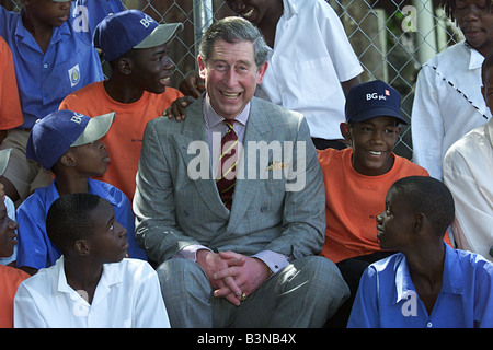 Britain s Prince Charles puts a baseball cap February 2000 Drawing laughter from a group of children at the Credo Center Playground in Port of Spain Trinidad Wednesday Feb 23 2000 British Gas donated a a science bus and vehicle to the center which houses and schools homeless children Prince Charles is on a four day visit to the Republic of Trinidad and Tobago Stock Photo