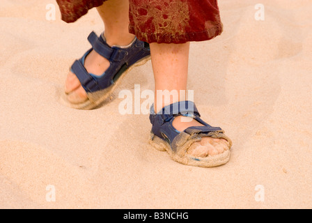 Close up of small boys sandy sandals on beach