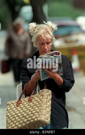 Paula Yates TV Presenter August 1998 Walking down the street reading a magazine Black shirt blue shirt mirrorpix Stock Photo