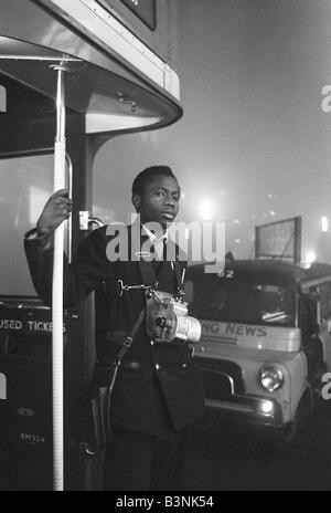 London Weather December 1962 A London Transport bus conductor looks out fron the platform of his Routemaster bus Stock Photo