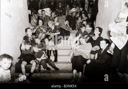 Families take cover from the Luftwaffe bombing of London in this disused London Underground railway tunnel September 1940 Stock Photo