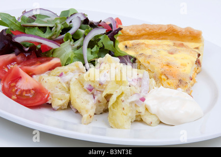 Quiche Lorraine with fresh salad on a white plate Stock Photo