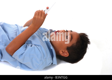 Ten year old boy playing with his hand held video game Stock Photo