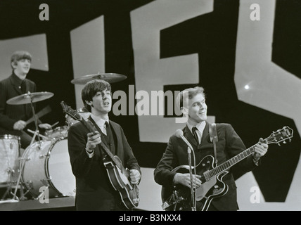 The Beatles rehearse for their appearance on the Ed Sullivan TV Show in New York George Harrison was bed ridden so roadie Neil Aspinall stood in for the rehearsal with George returning for the Live TV broadcast Neil plays lead guitar with Paul McCartney and Ringo Starr February 1964 Stock Photo