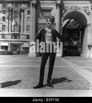 Fashions taken during London Fashion Week 1964 Long tight velvet trousers with waiscoat style jacket and ankle length pointed boots standing in front of Marble Arch with her hands on her hips Stock Photo