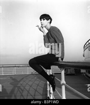 Peggy Moffitt October 1965 Top American fashion model pictured on Queen Elizabeth when arriving at Southampton Miss Moffit who modelled the original bathing costume is to appear in a fashion award show at Hilton Hotel London Here she is wearing a mini skirt with tights and a jumper with her hair in a short bob sitting on decking Stock Photo