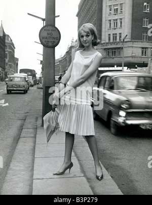 A modle wearing Mary Quant Good Girl fashions for spring 1964 in london fashion women woman ladies skirt high heel shoes top holding umbrella 1960s msi 5 2 64 Stock Photo