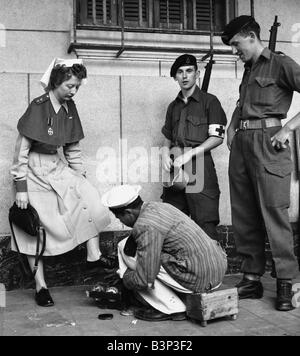 Suez Crisis 1956 British Army nurse Jean Leich has her shoes shined in Port Said s main street Stock Photo