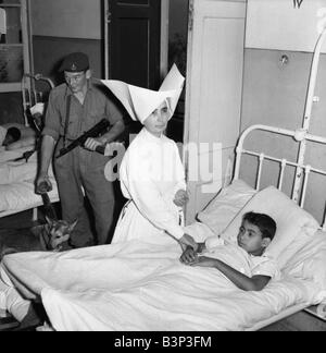 Suez Crisis 1956 Royal Marine Andrew Hall accompanies Sister Mary Joseph on her rounds at a hospital in Port Said Sister Mary from the Sister of Charity Convant in London has tended the sick at the hosptal for three years The armed guard was assigned to her after she received death threats for tipping off the British army that fifty rifles and a large quantity of ammunition were hidden in a clothes store Stock Photo