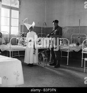 Suez Crisis 1956 Royal Marine Andrew Hall accompanies Sister Mary Joseph on her rounds at a hospital in Port Said Sister Mary from the Sister of Charity Convant in London has tended the sick at the hosptal for three years The armed guard was assigned to her after she received death threats for tipping off the British army that fifty rifles and a large quantity of ammunition were hidden in a clothes store Stock Photo