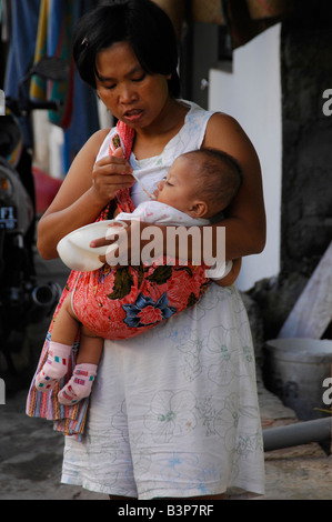 mother with baby, slum neighbourhood in kuta , bali , indonesia Stock Photo