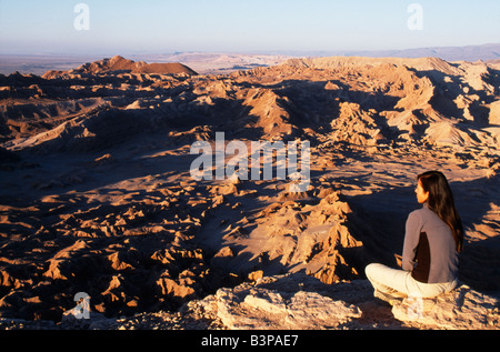 Chile, Atacama Desert, San Pedro de Atacama. Trekker watches the sun set over the Atacama Desert. Stock Photo