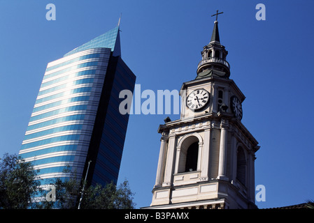 Chile, Santiago. Rising either side of Avenida del Libertador Bernardo O'Higgins, Santiago's main east-west throughfare, colloquially known as La Alameda, are the two faces of Santiago. On the left a modern high-rise office building and on the right the tower of Iglesia San Francisco, Santiago's oldest building (built in 1586-1628AD) Stock Photo