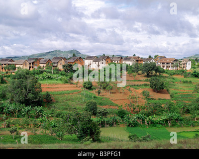 Madagascar, Southern Highlands, Andohatangona. An attractive Malagasy village of the Betsileo people who live southwest of the capital, Antananarivo.Most houses in the village are double-storied with kitchens and living quarters located on the first floor. Almost all of them have wooden balconies and some have outside staircases. Livestock is often kept in the ground floor of a house overnight.The Betsileo are industrious people and expert rice farmers. Their terraced, irrigated paddy fields are a feature of Madagascar's southern landscape. Stock Photo