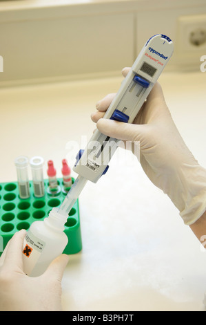 Hand in a sterile glove pipetting with a pipettor in a laboratory Stock Photo