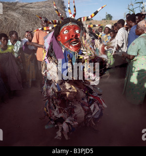 Malawi, Mua, Central Malawi. The Chewa people, Malawi's largest ethnic group, live on the west side of Lake Malawi. Despite years of missionary influence, they still cling to old beliefs and rituals. For them, death simply means a journey of rebirth into the spirit world. The terrestrial representatives of this other world are grotesquely masked dancers known as Gule Wamkulu. When a person dies, masked dancers appear at the funeral to welcome the deceased to the spirit world. Stock Photo