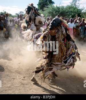 Malawi, Mua, Central Malawi. The Chewa people, Malawi's largest ethnic group, live on the west side of Lake Malawi. Despite years of missionary influence, they still cling to old beliefs and rituals. For them, death simply means a journey of rebirth into the spirit world. The terrestrial representatives of this other world are grotesquely masked dancers known as Gule Wamkulu. When a person dies, masked dancers appear at the funeral to welcome the deceased to the spirit world. Stock Photo