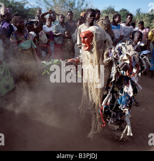 Malawi, Mua, Central Malawi. The Chewa people, Malawi's largest ethnic group, live on the west side of Lake Malawi. Despite years of missionary influence, they still cling to old beliefs and rituals. For them, death simply means a journey of rebirth into the spirit world. The terrestrial representatives of this other world are grotesquely masked dancers known as Gule Wamkulu. When a person dies, masked dancers appear at the funeral to welcome the deceased to the spirit world. Stock Photo