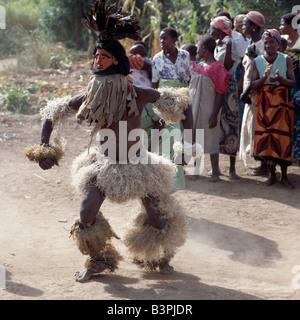 Malawi, Mua, Central Malawi. The Chewa people, Malawi's largest ethnic group, live on the west side of Lake Malawi. Despite years of missionary influence, they still cling to old beliefs and rituals. For them, death simply means a journey of rebirth into the spirit world. The terrestrial representatives of this other world are grotesquely masked dancers known as Gule Wamkulu. When a person dies, masked dancers appear at the funeral to welcome the deceased to the spirit world. Stock Photo