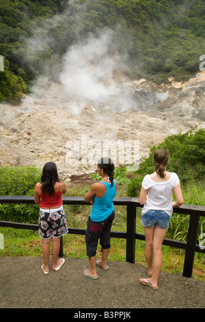 Three teenage children people looking at the volcanic caldera, Soufriere, St Lucia, West Indies Stock Photo