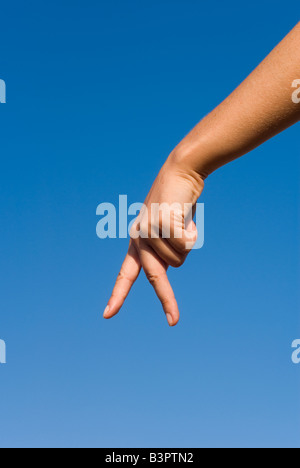 Model Released Detail of female hand forming a walking sign Stock Photo