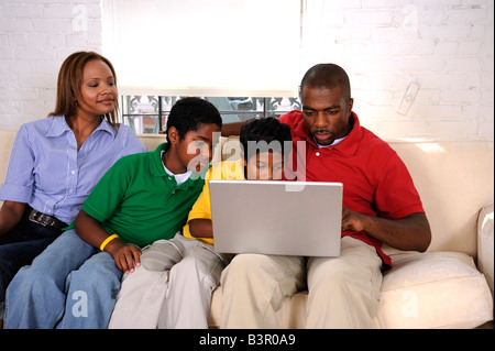 African American family staring at a laptop computer Stock Photo