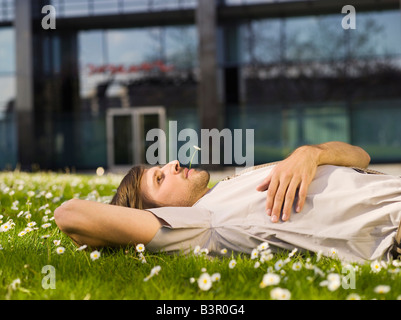 Germany, Baden-Württemberg, Stuttgart, Businessman taking a break, lying on back Stock Photo