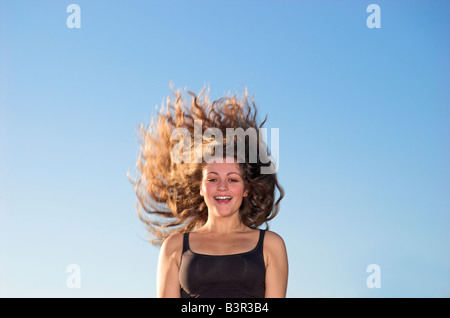Teenage girl 16 18 with long hair tossing head back portrait Stock Photo