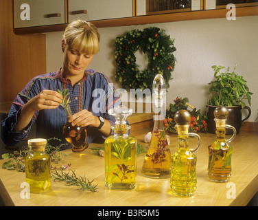 woman pickling herbs in vinegar and oil Stock Photo