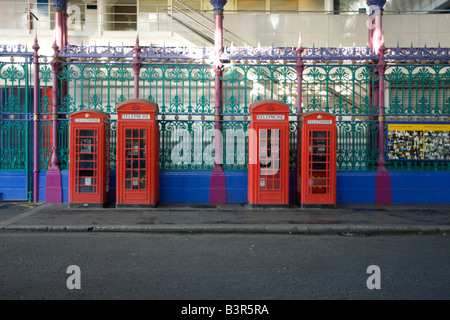 Four red London phone boxes in a row note the different sizes Stock Photo