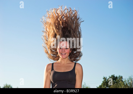 Smiling teenage girl 16 18 with long hair tossing head back portrait Stock Photo