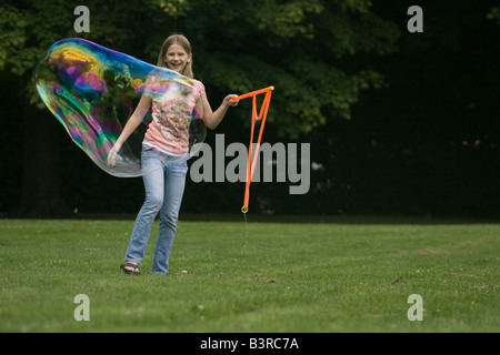 Young girl making large soap bubbles Stock Photo