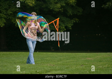 Young girl making large soap bubbles Stock Photo