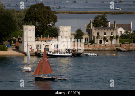 Small boats sail past the landing point on Brownsea Island, Poole, Dorset, UK Stock Photo