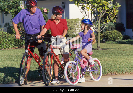 Grandmother and grandkids, cycling together in park, Miami. Stock Photo