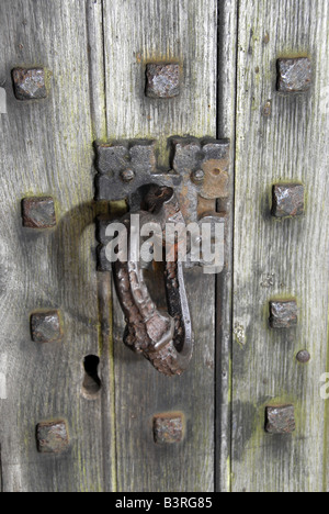 Old rusty ornate iron handle and escutcheon on weathered studded oak medieval church door Stock Photo