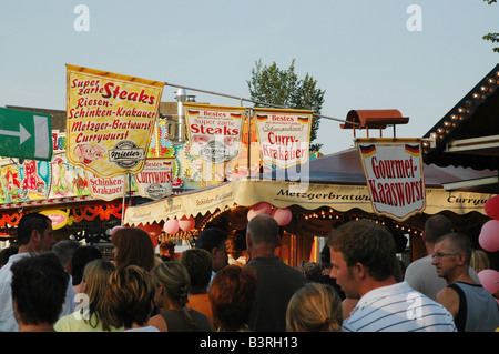 colourful fairground with spectators at dusk Tilburg Netherlands Stock Photo