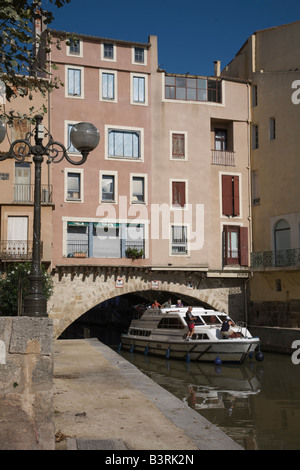 Leisure craft sailing under the the Pont des Marchands on Canal de la Robine at Narbonne Stock Photo
