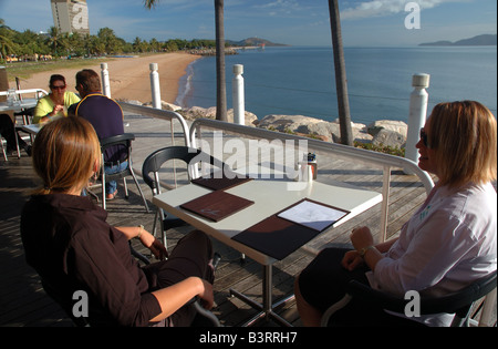 Breakfast at cafe overlooking The Strand, Townsville's city beach, with Magnetic Island visible across the bay, Queensland Stock Photo