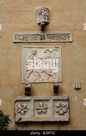 Wall with collection of ancient stone relief in a courtyard, Rome Italy Stock Photo