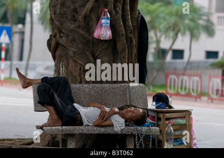 Elderly man sleeping on a bench, in Hanoi, Vietnam Stock Photo