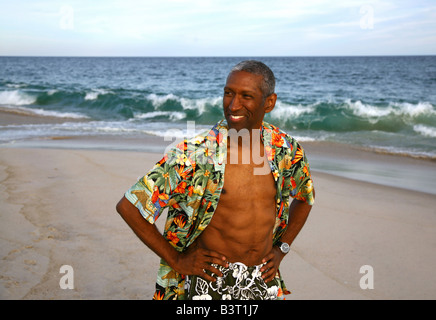 Mature African American man walking on beach Stock Photo