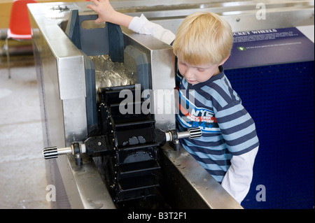 Child looking at interactive dispaly waterwheel at Stanley Mills visitor centre A historic cotton mill Perthshire Scotland Stock Photo