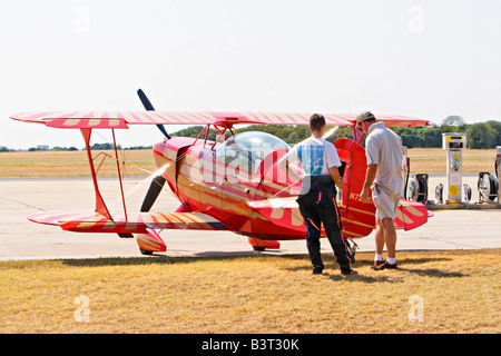 Two pilots talking with each other beside acrobatic biplane airplane Stock Photo