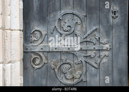 Large ornate hinge and keyhole on the door of St Aidan's Church Church  in Bamburgh Great Britain Stock Photo