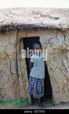 Africa, Kenya, Masai Mara National Wildlife Reserve. Girl in doorway of Masai Mara village dwelling.