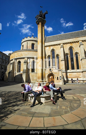 England, London, Office workers relaxing in the sunshine outside Temple Church. Temple Church is a late 12th Century church orig Stock Photo
